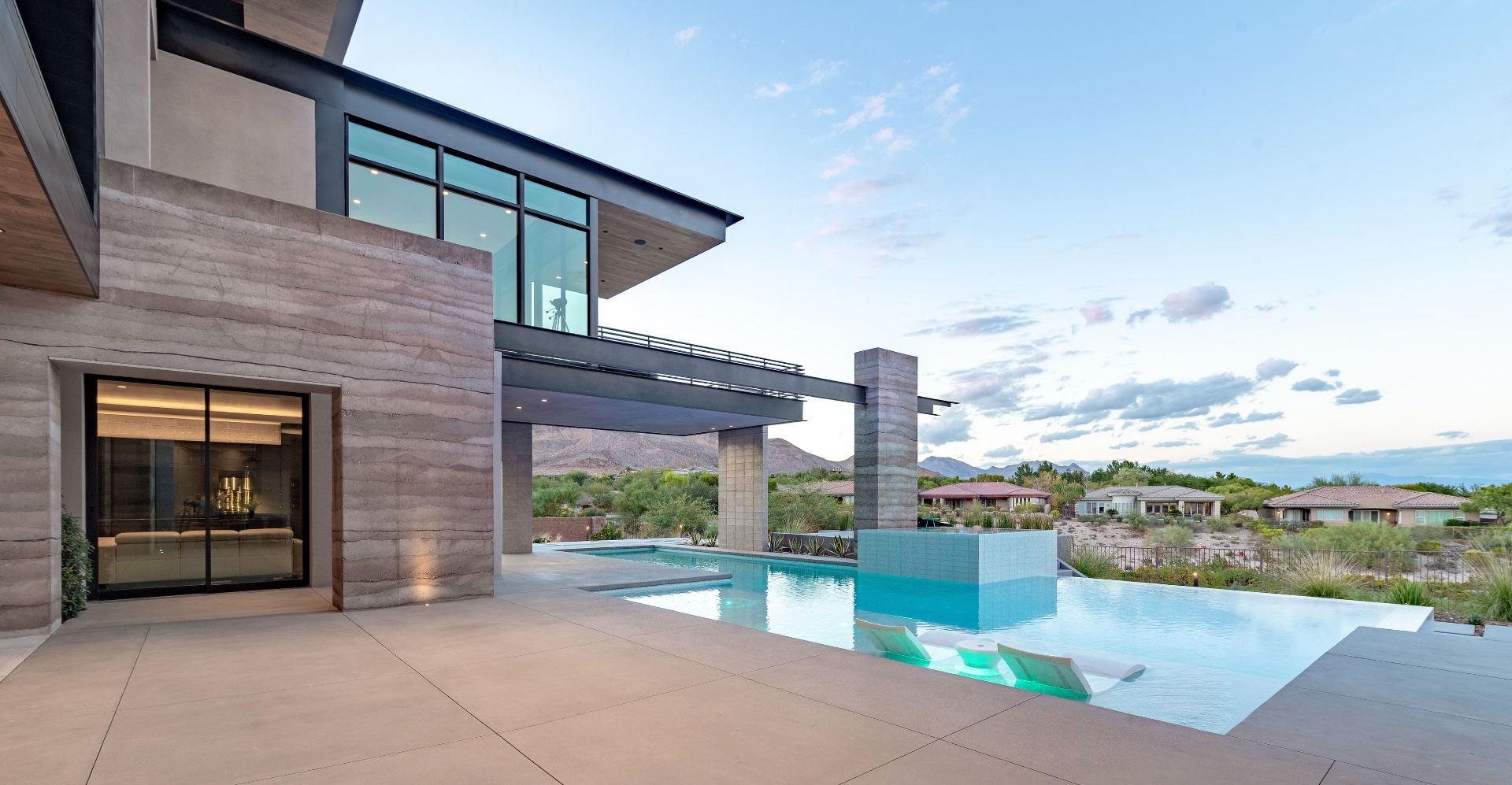 Custom residence with pool, concrete decks, and rammed earth walls by DCI in Las Vegas, Nevada